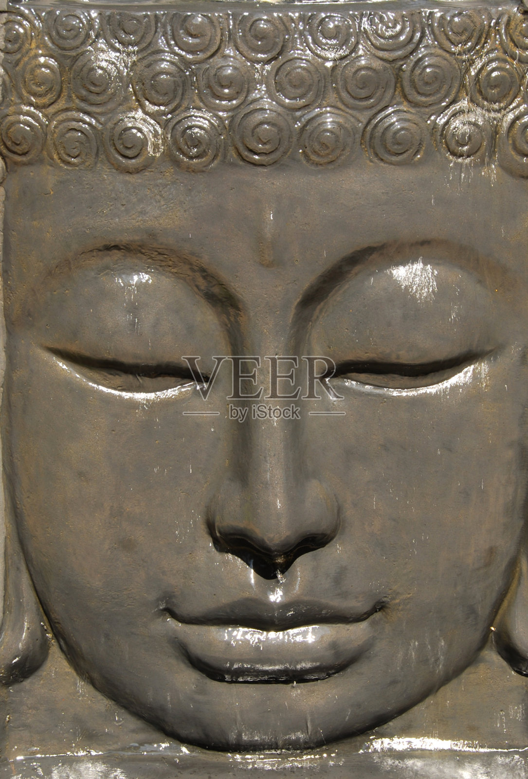 佛面带流水。照片摄影图片