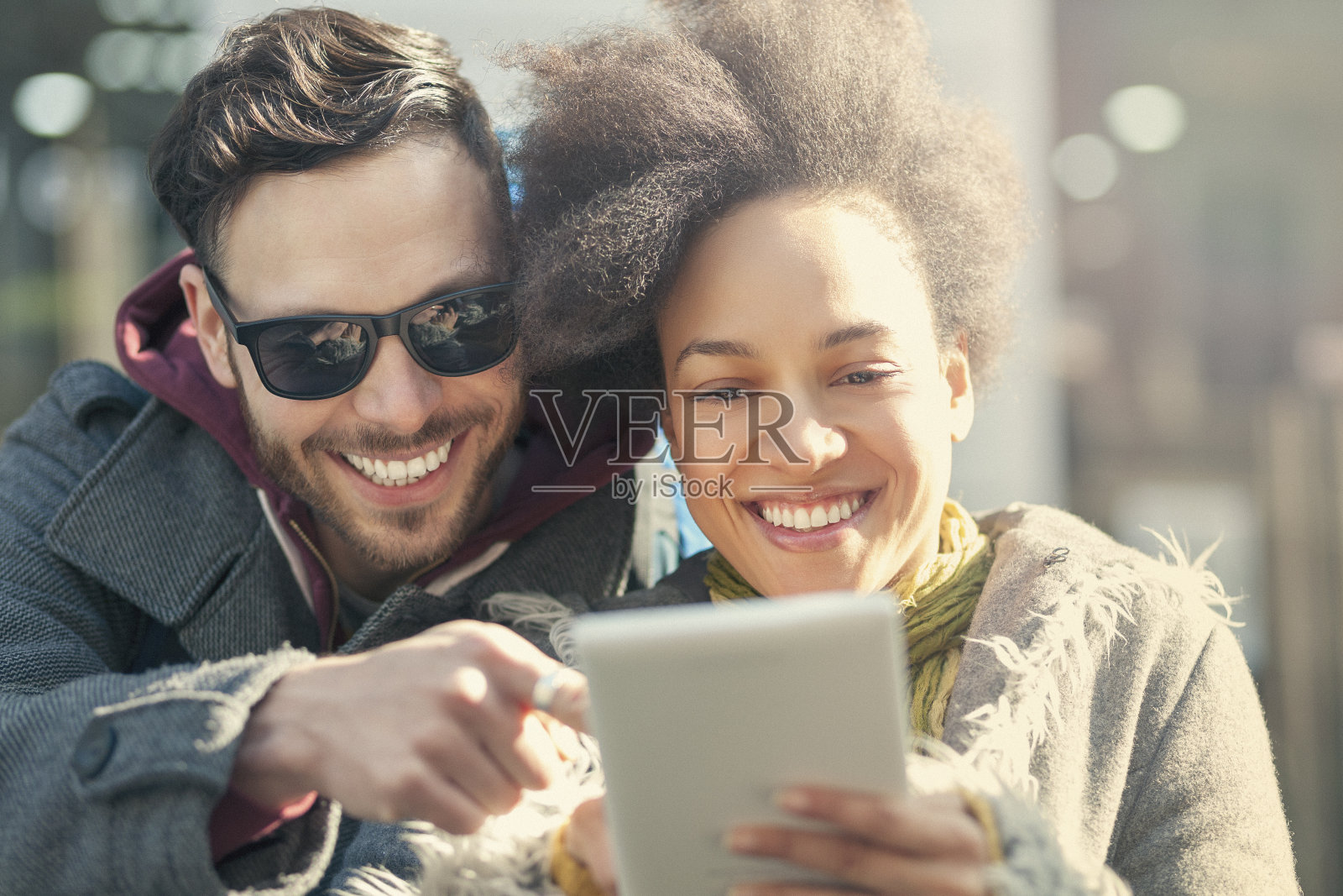 美丽的年轻夫妇在城市中使用平板电脑照片摄影图片