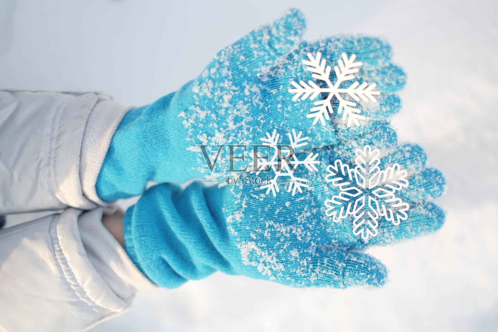 女人的手捧着雪花。照片摄影图片