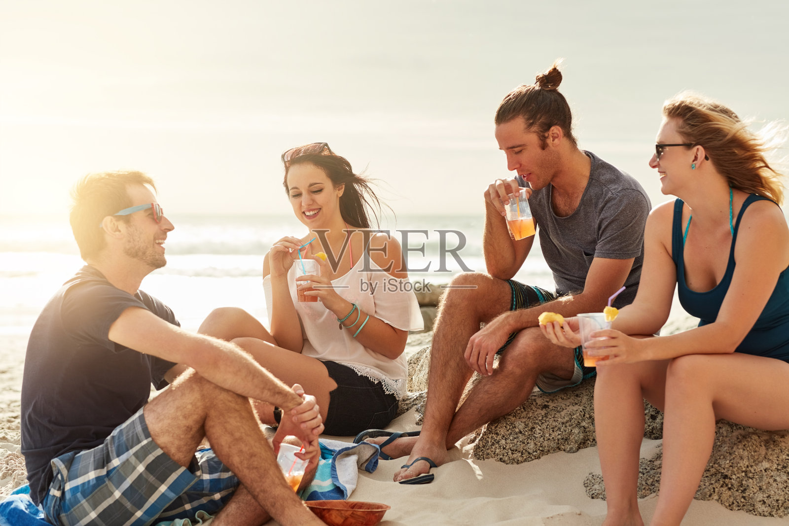 脚趾在沙子里,手里拿着饮料照片摄影图片