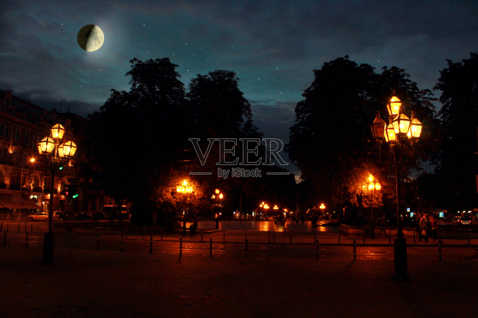 月亮和闪亮的星星照耀着夜晚的城市照片摄影图片