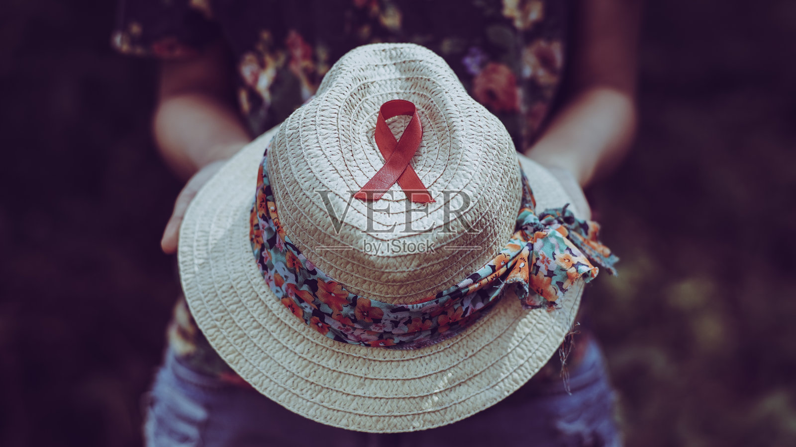 手持帽子上的红色丝带照片摄影图片