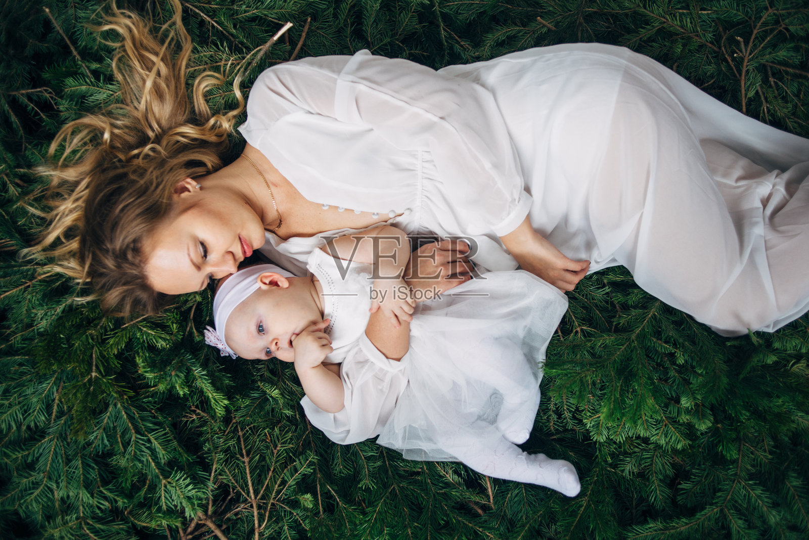 妈妈和女儿躺在圣诞树上照片摄影图片