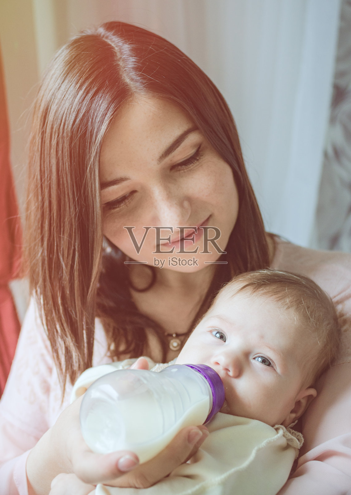 一位年轻的母亲正在喂养孩子照片摄影图片