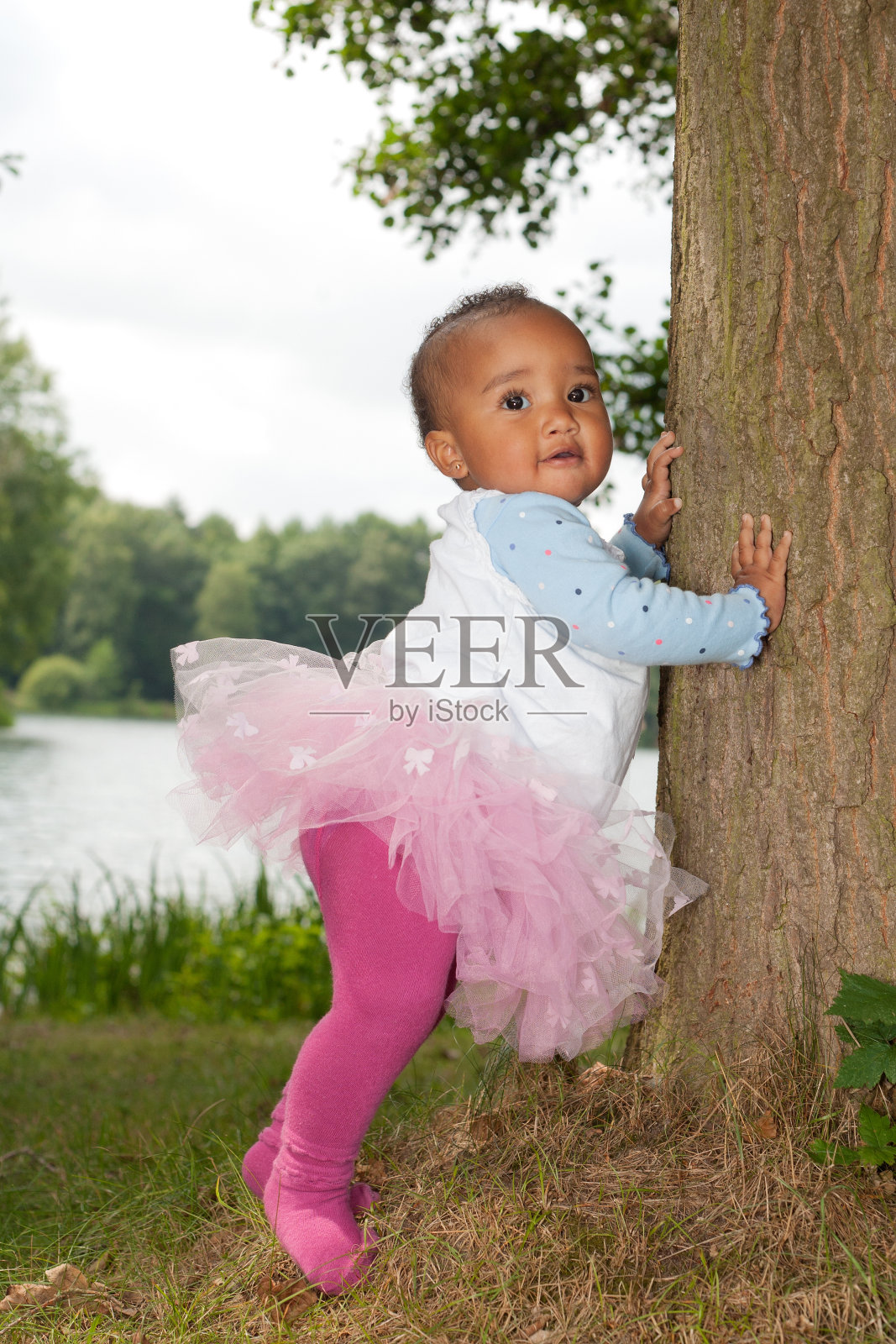 非洲小女孩正抱着树照片摄影图片