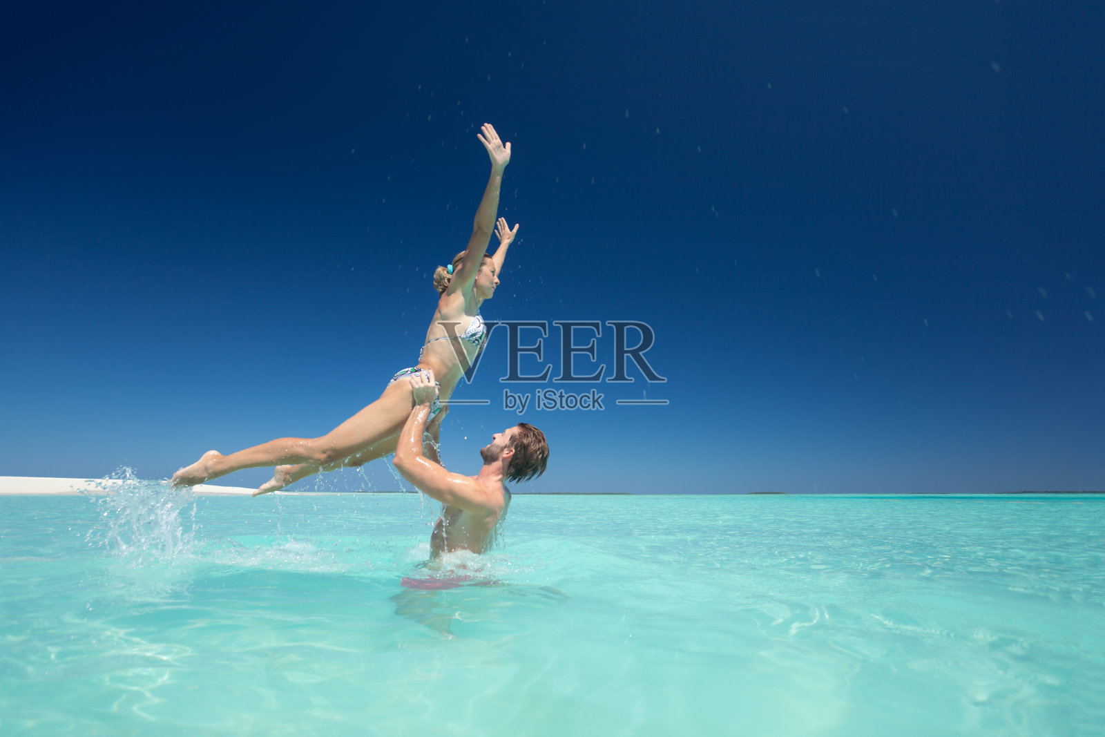 在热带泻湖的一对顽皮的夫妇照片摄影图片