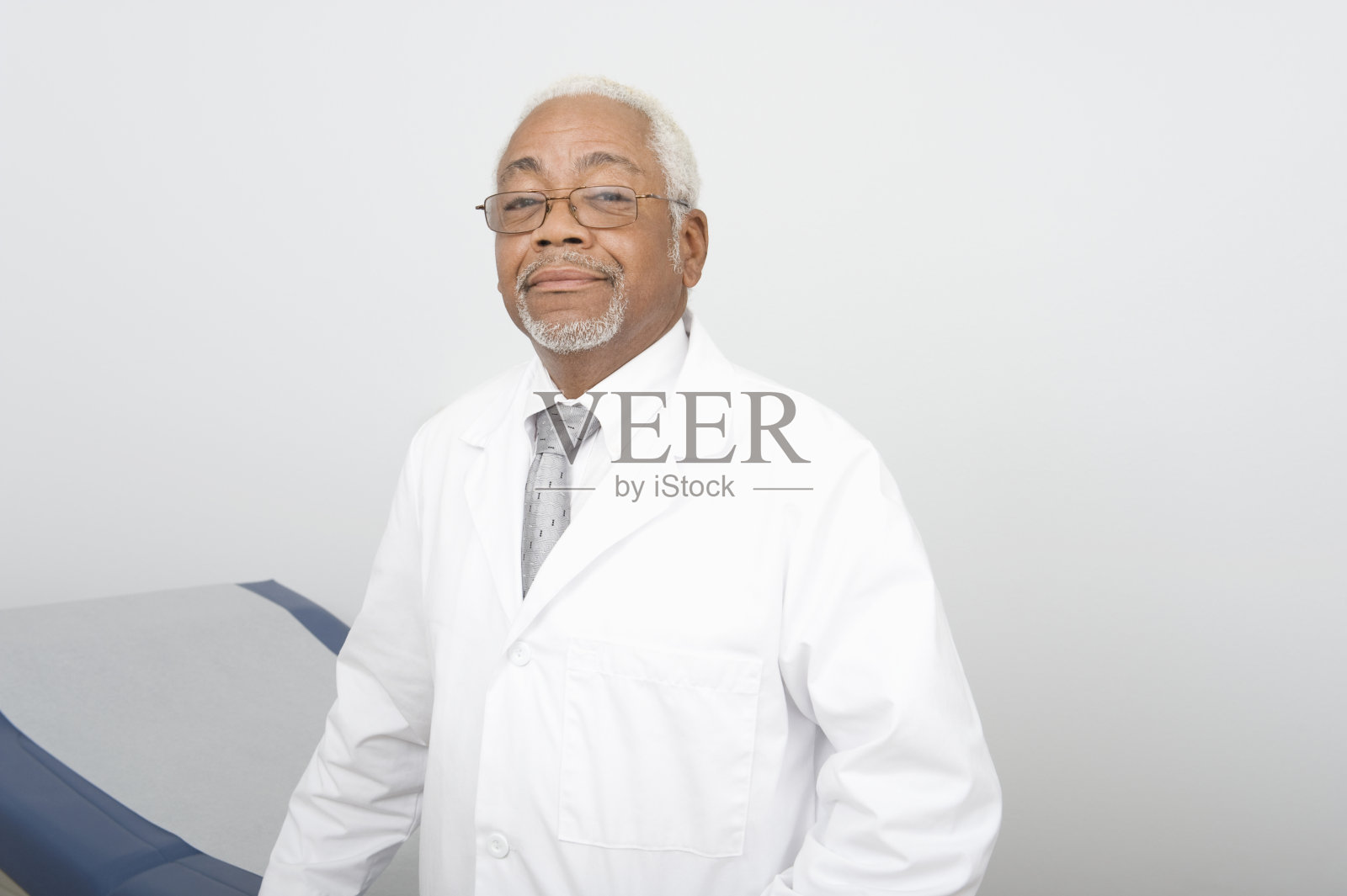 自信的资深男医生站在诊所照片摄影图片