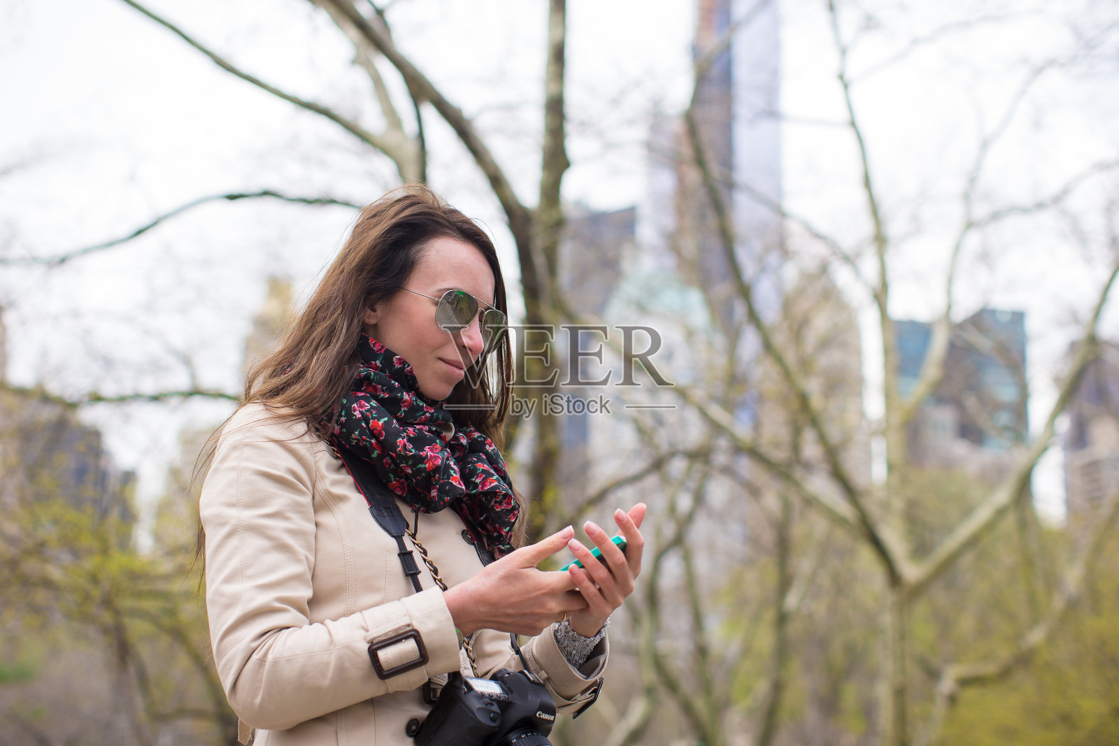 一个年轻女孩在公园里拿着手机照片摄影图片