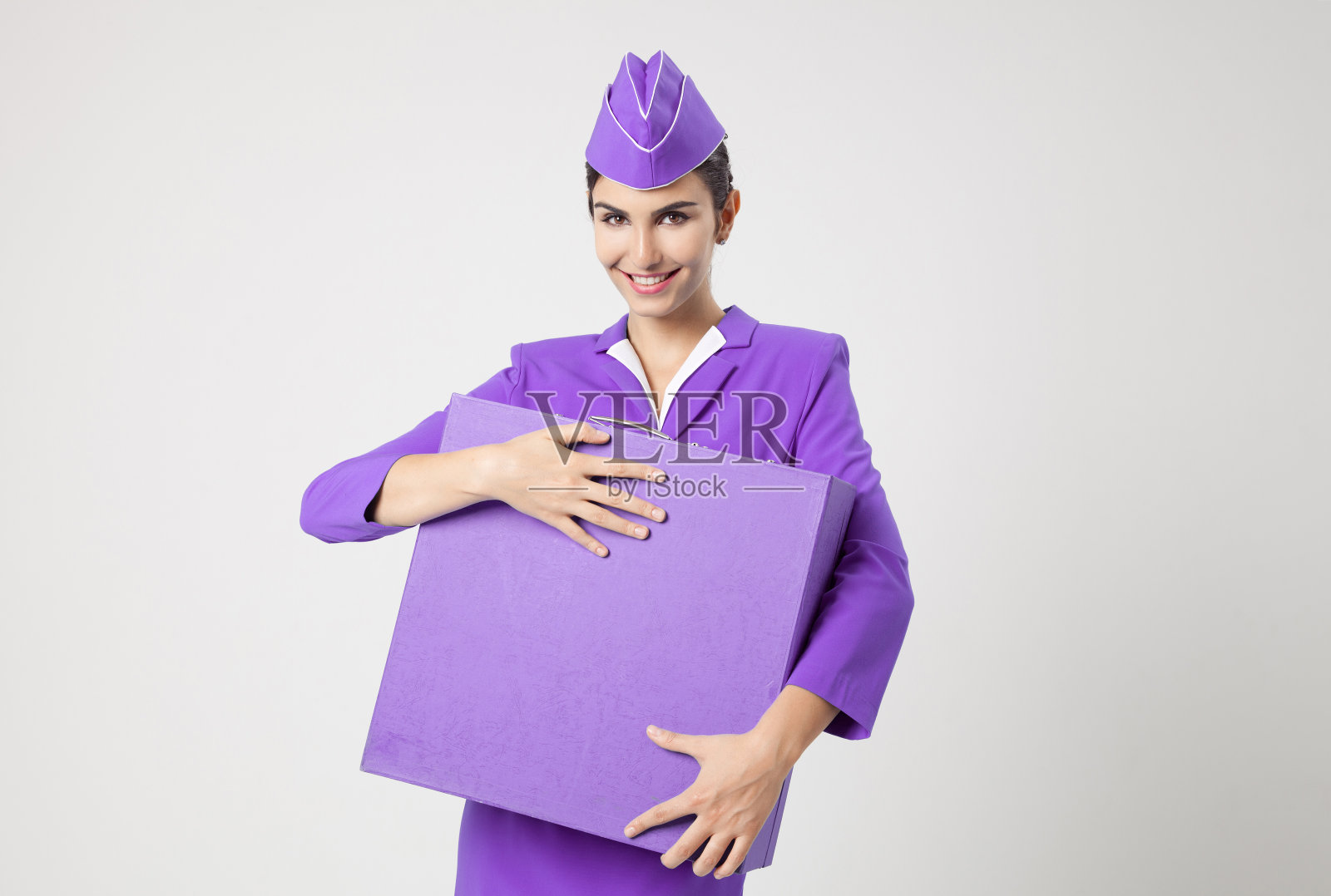 穿着紫色制服和手提箱的迷人空姐照片摄影图片