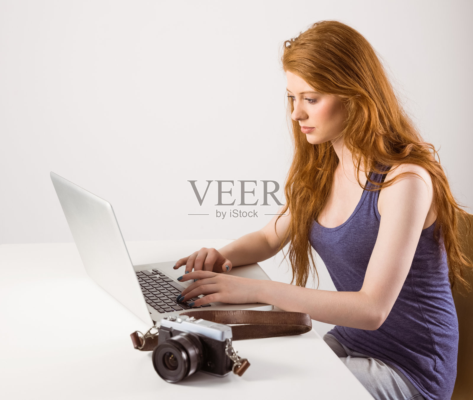 一个用笔记本电脑工作的红发美女照片摄影图片