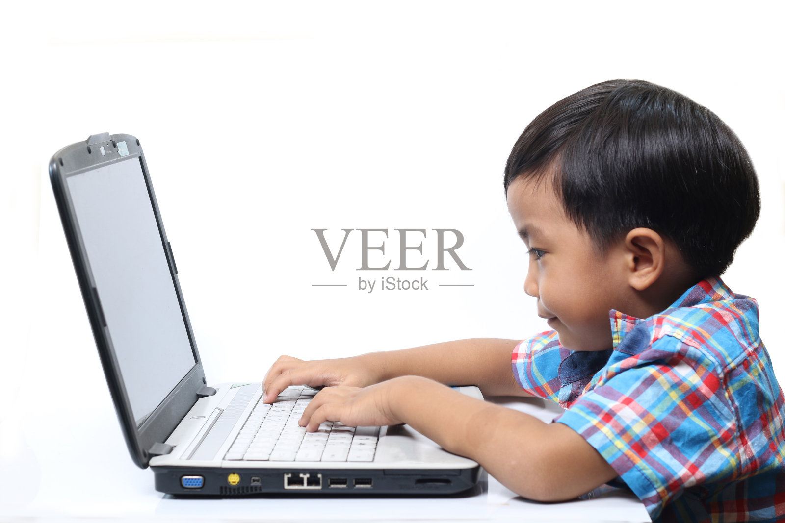 亚洲小男孩用笔记本电脑打白种人照片摄影图片