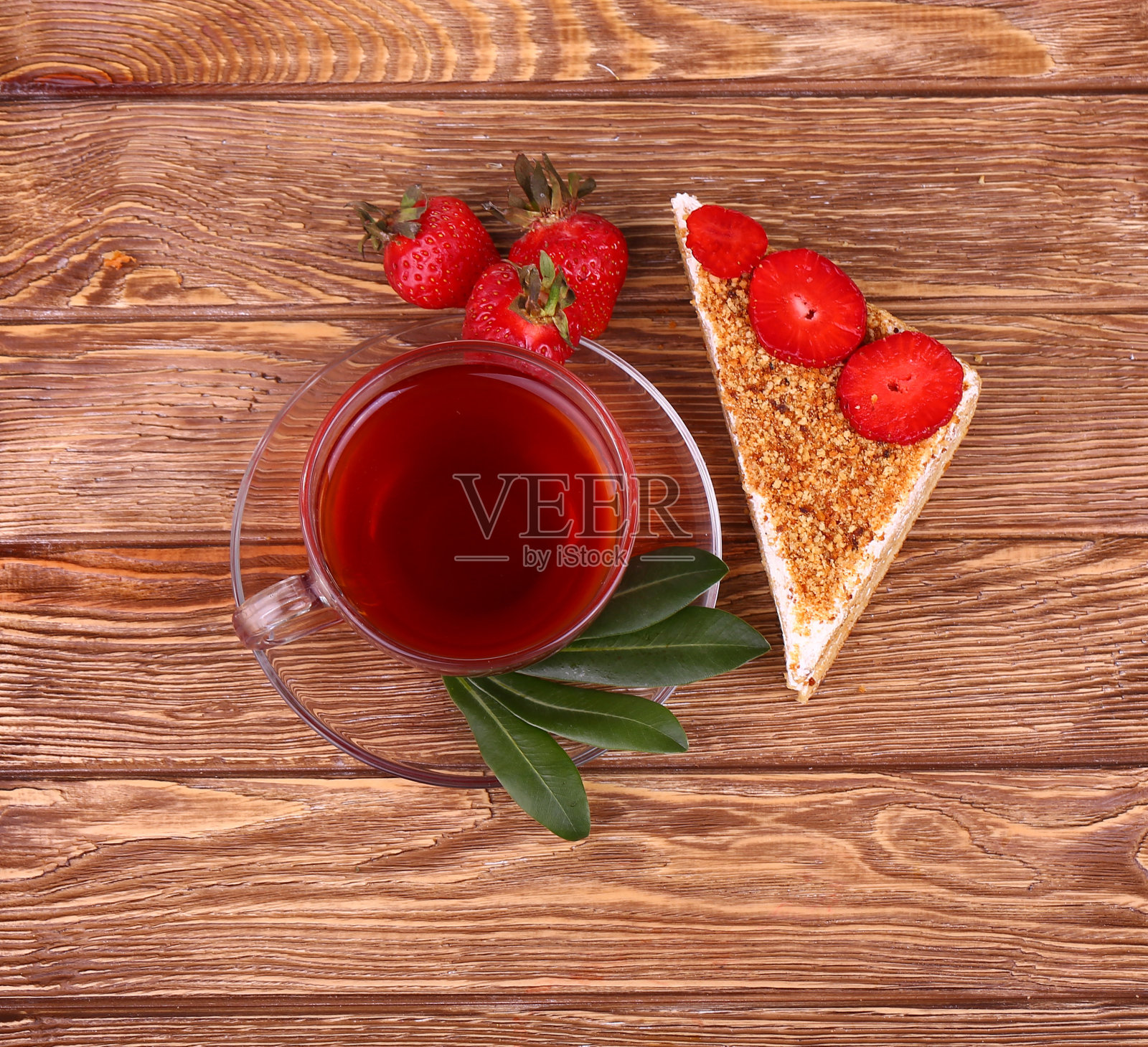 甜蛋糕和一杯茶放在木桌上照片摄影图片
