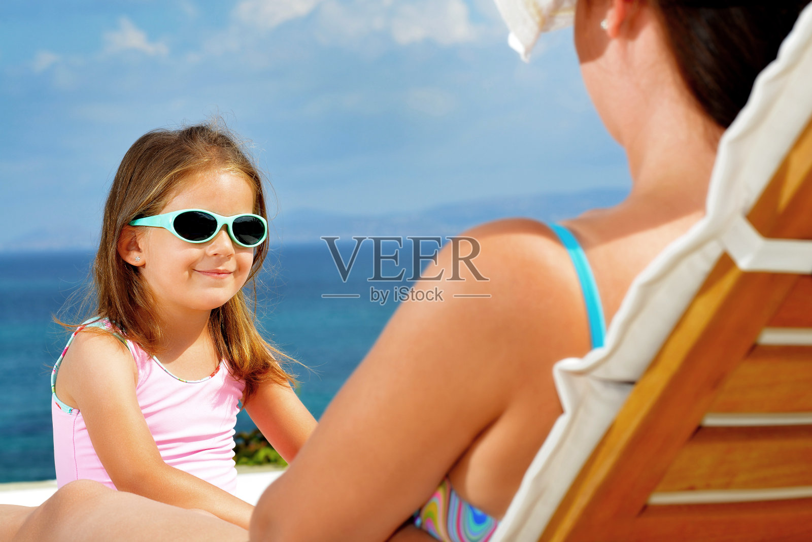 小女孩躺在日光浴床上照片摄影图片