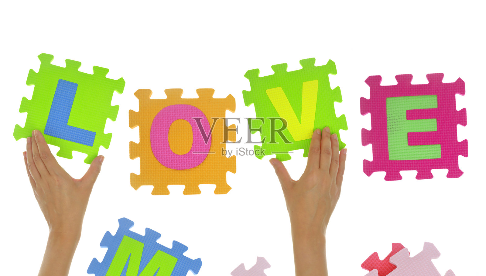 双手用拼图碎片拼出“爱”字照片摄影图片