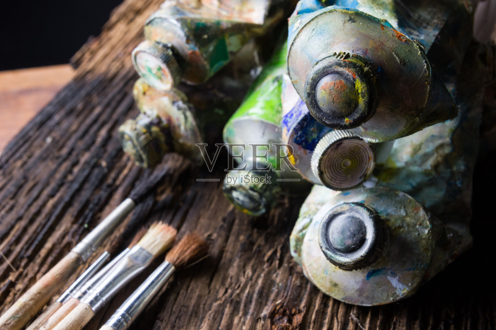 艺术家的画笔近距离地在旧的自然木制书桌的背景上。照片摄影图片