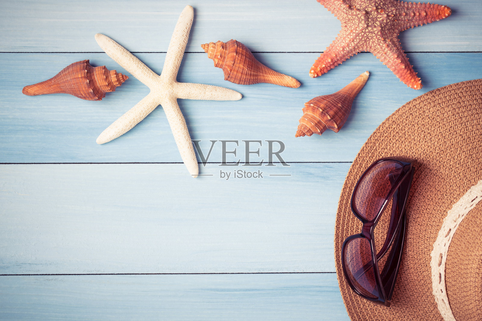 海星帽和贝壳放在蓝色的木地板上照片摄影图片