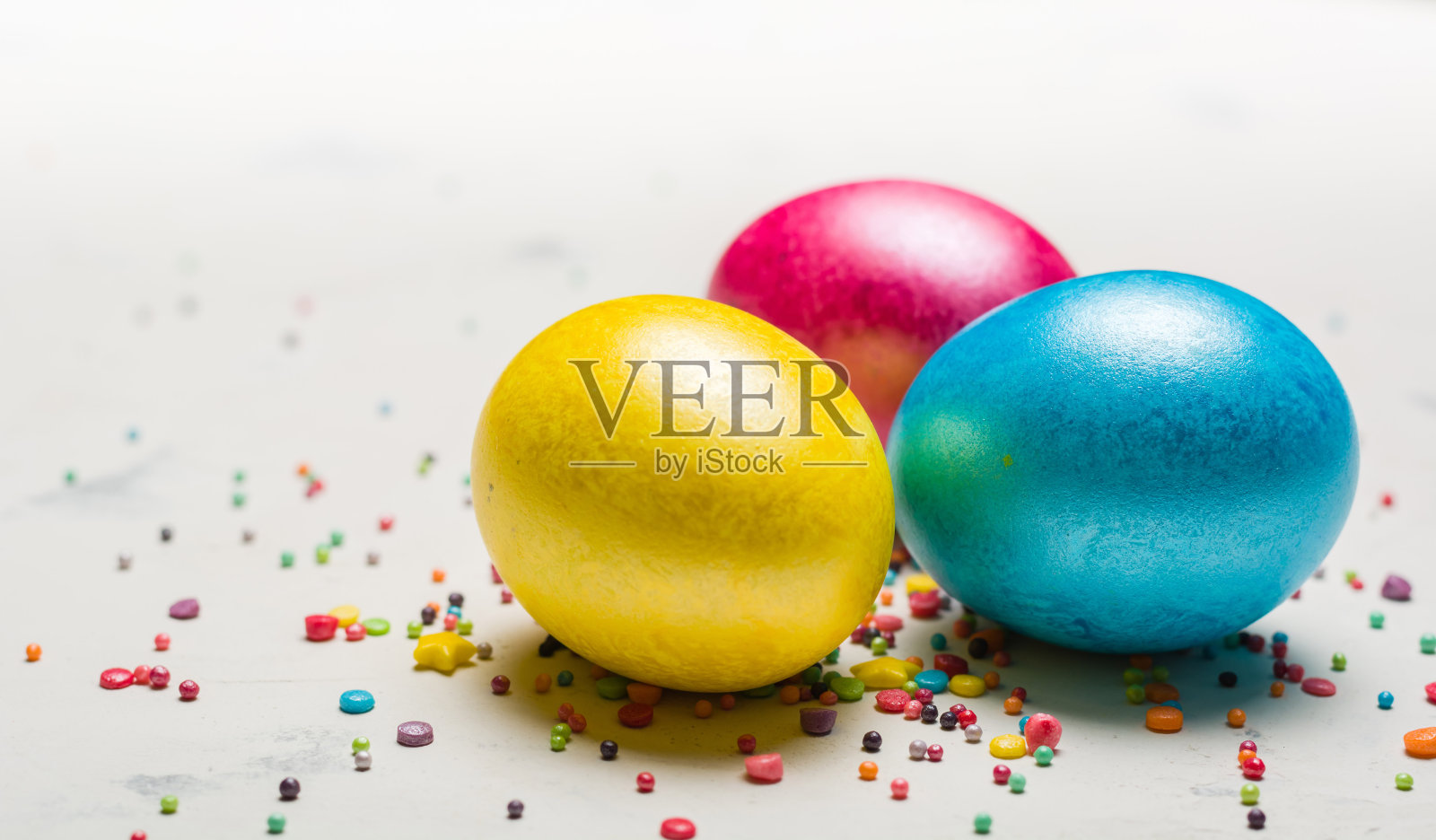 复活节背景用五颜六色的鸡蛋放在白色的石板上。照片摄影图片