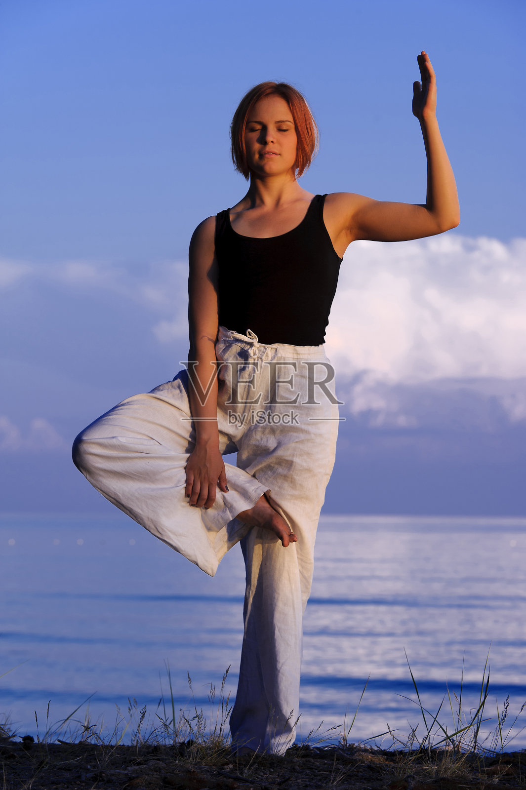 一个年轻女人在外面做瑜伽照片摄影图片