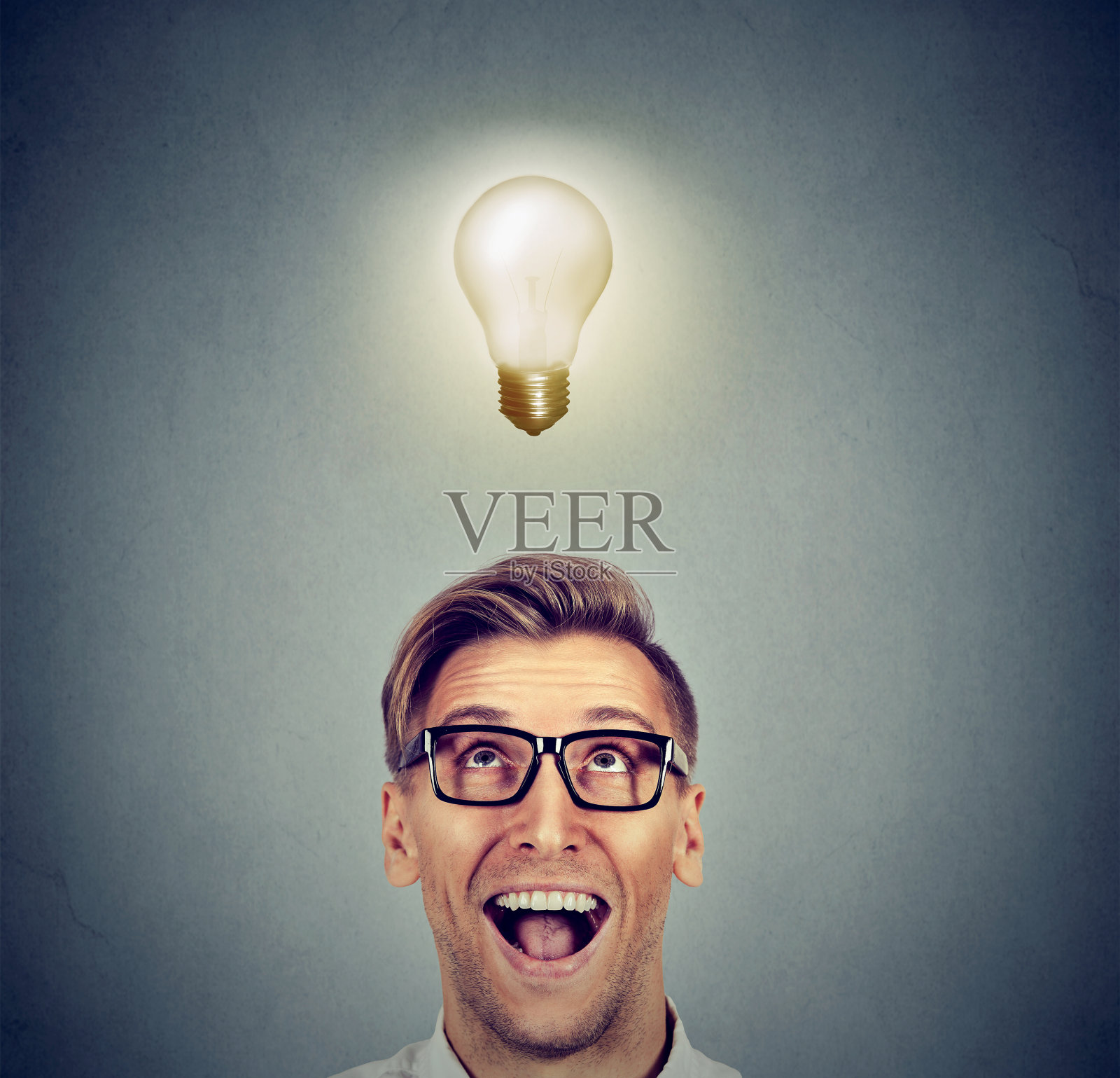 兴奋的快乐的人戴着眼镜看着灯泡的想法照片摄影图片