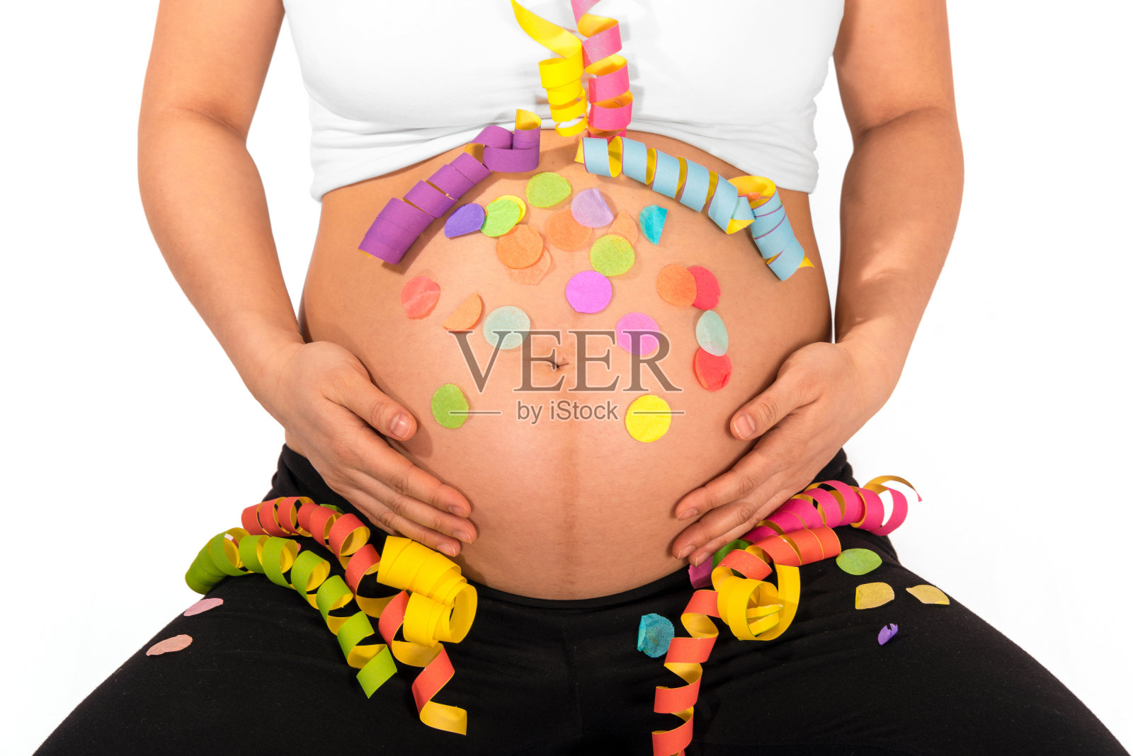 彩色的彩带和五彩纸屑在孕妇裸露的肚子上照片摄影图片