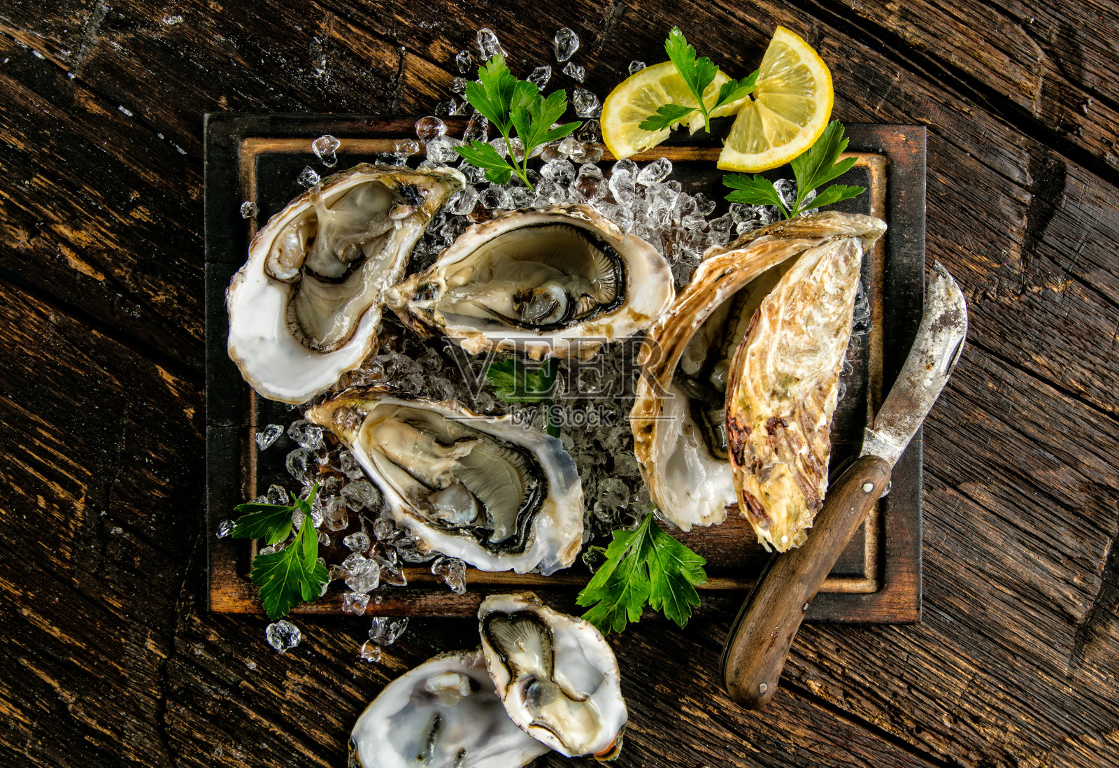 牡蛎装在带有冰块的木板上照片摄影图片