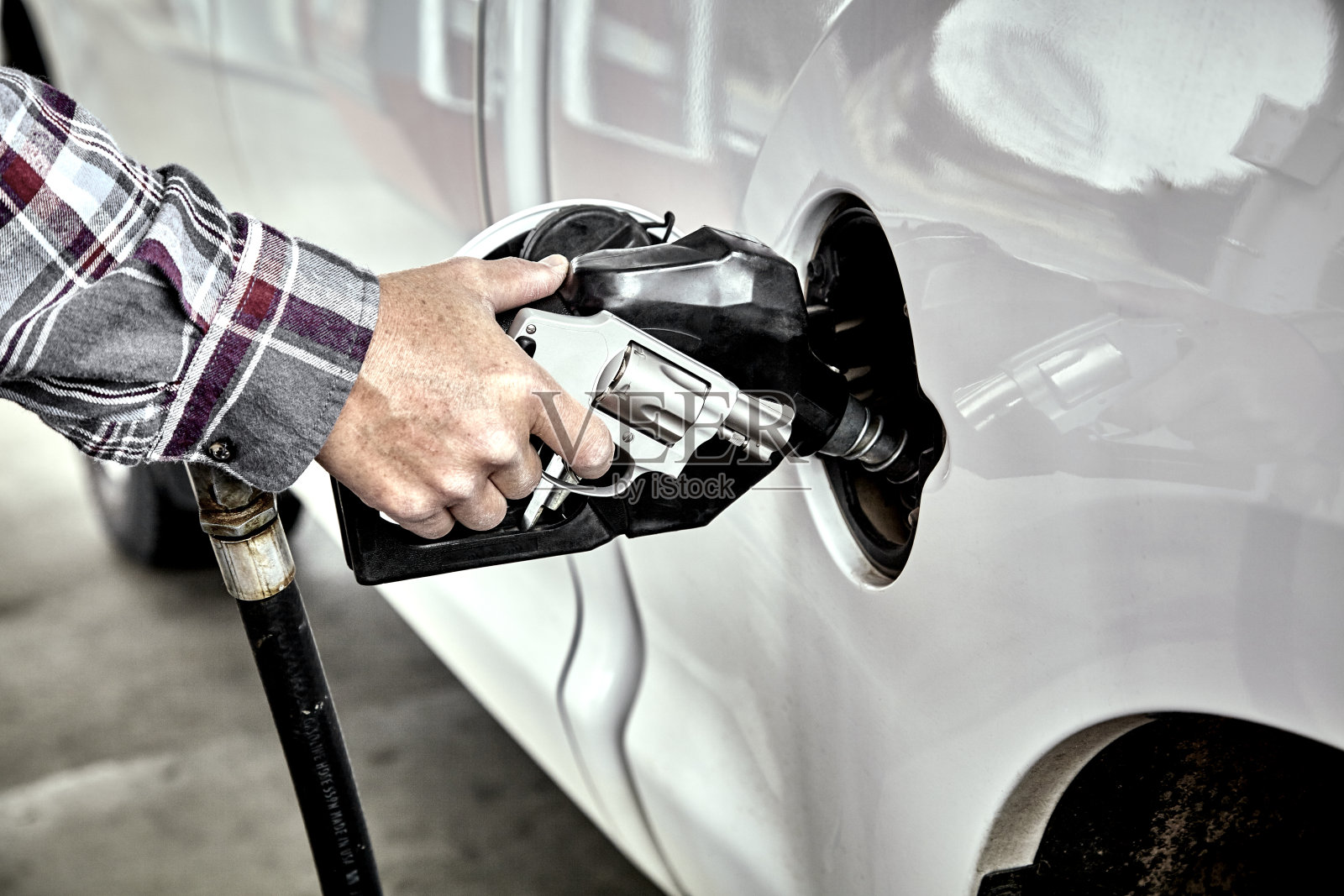 男子手持手枪为车辆加油照片摄影图片