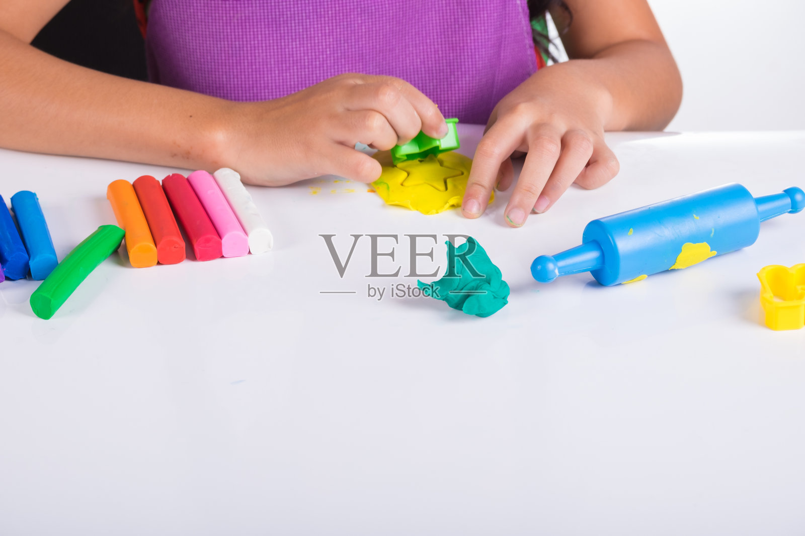 小朋友的小手在白色的桌上学习玩彩色的面团照片摄影图片