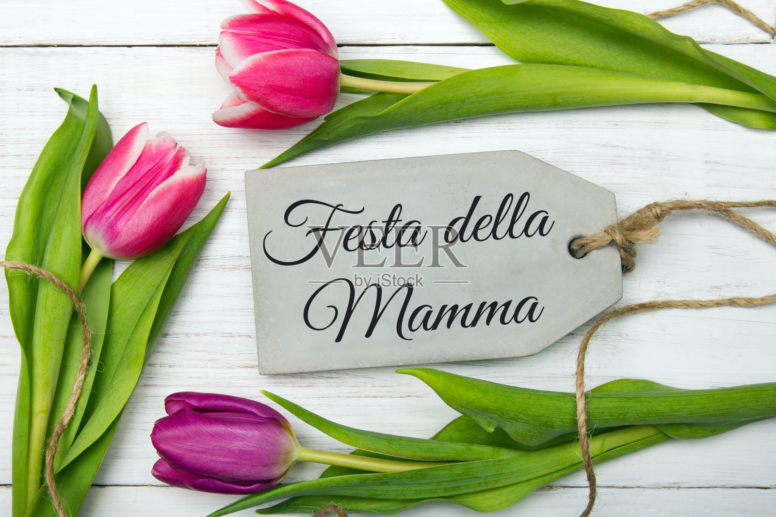 用意大利语写的母亲节贺卡:母亲节快乐。白色木质背景上的郁金香花束,复制空间照片摄影图片