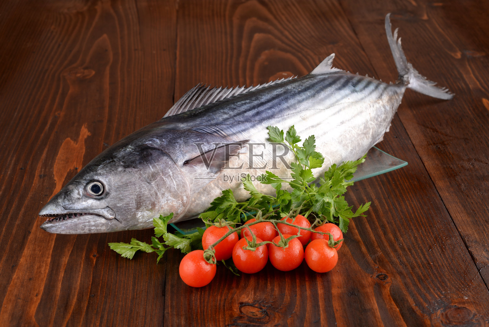 桌上放着切碎的金枪鱼、欧芹和樱桃番茄照片摄影图片