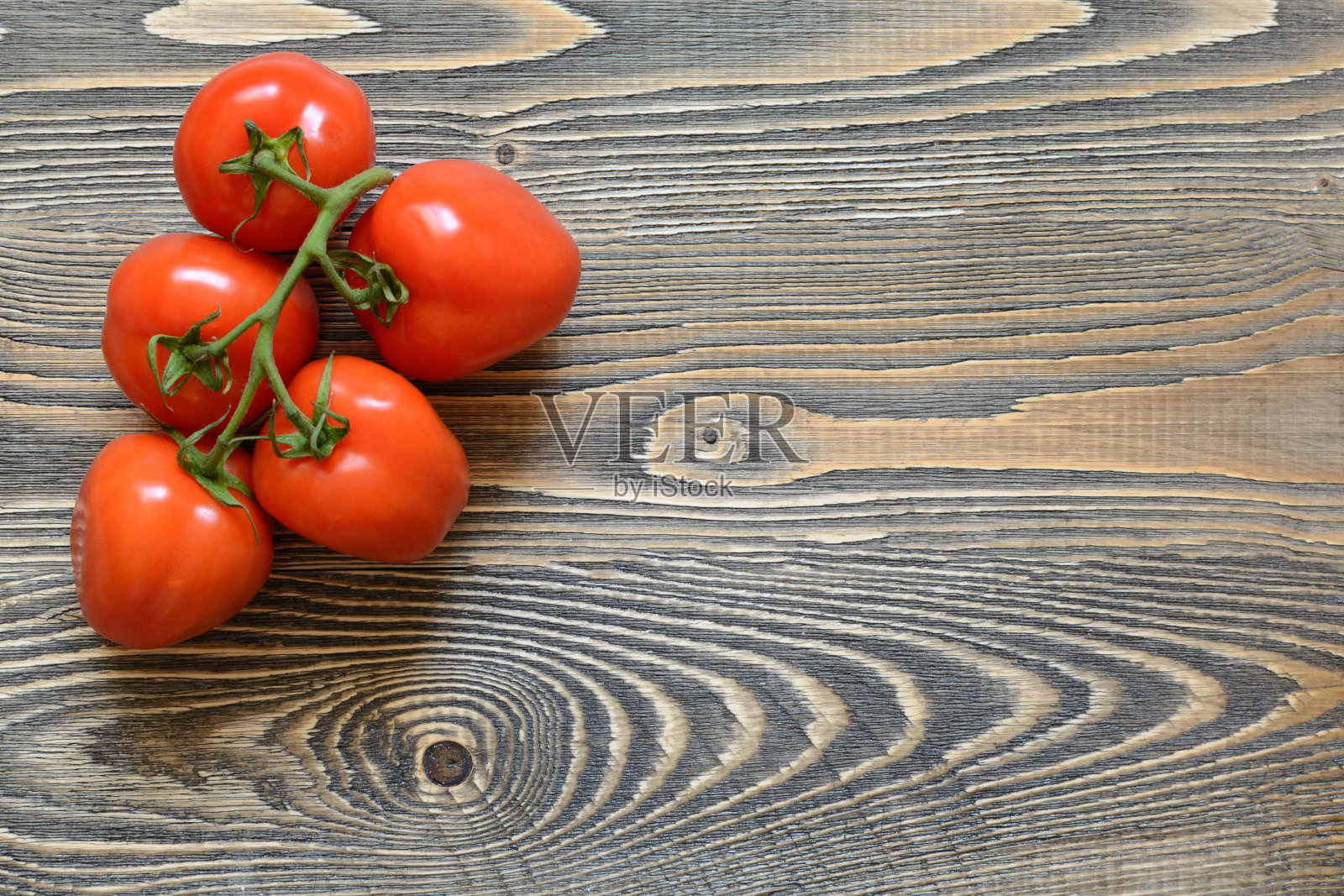 木背景上的绿色树枝上五个红色的西红柿照片摄影图片