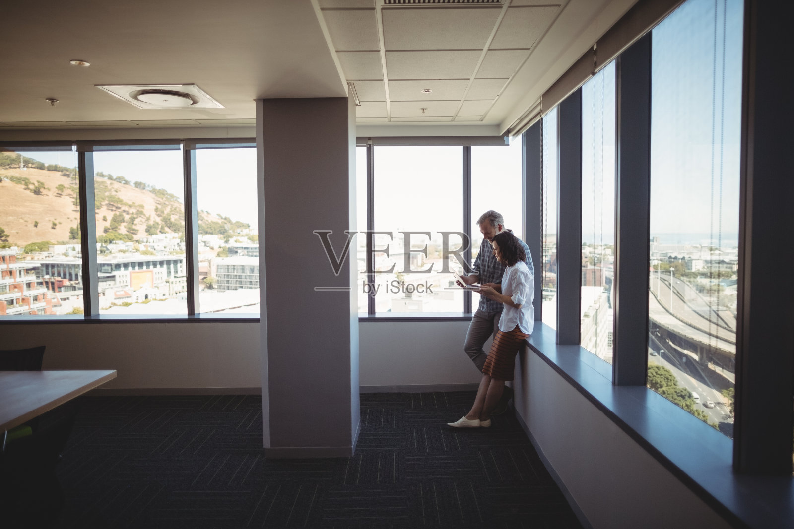 商务主管在窗边使用笔记本电脑照片摄影图片