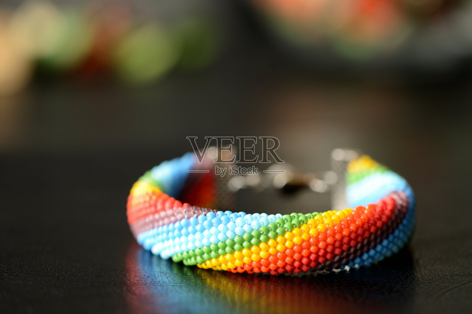 珠子钩针手链的彩虹颜色在一个黑暗的背景照片摄影图片