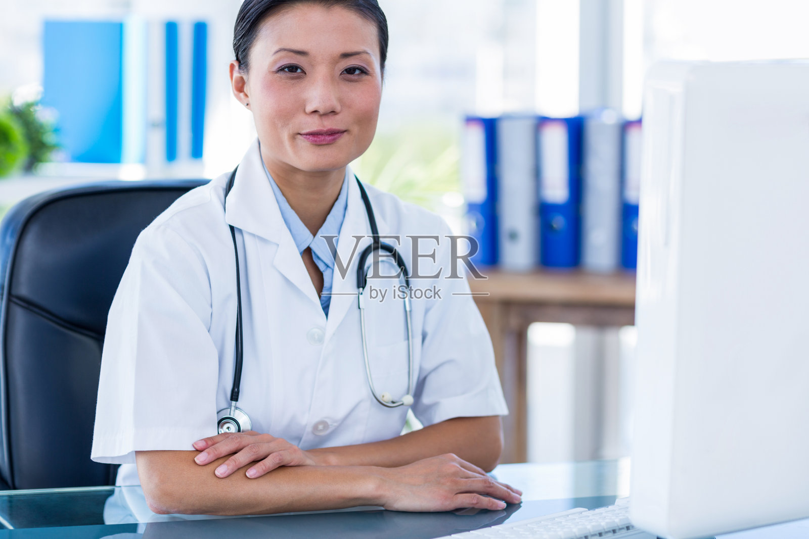 自信的医生双臂交叉看着摄像机照片摄影图片