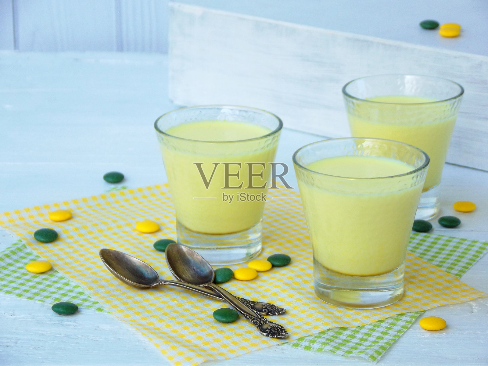 浅色背景下,装在玻璃杯中的姜黄牛奶凝乳甜点,健康食品照片摄影图片