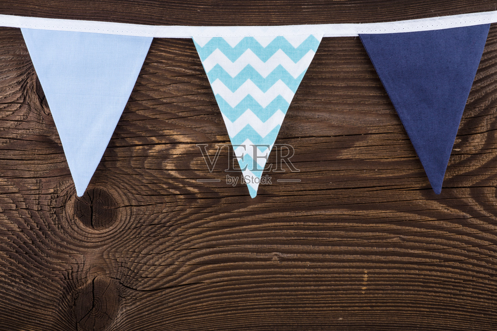 三角形的彩旗挂在绳子上。照片摄影图片