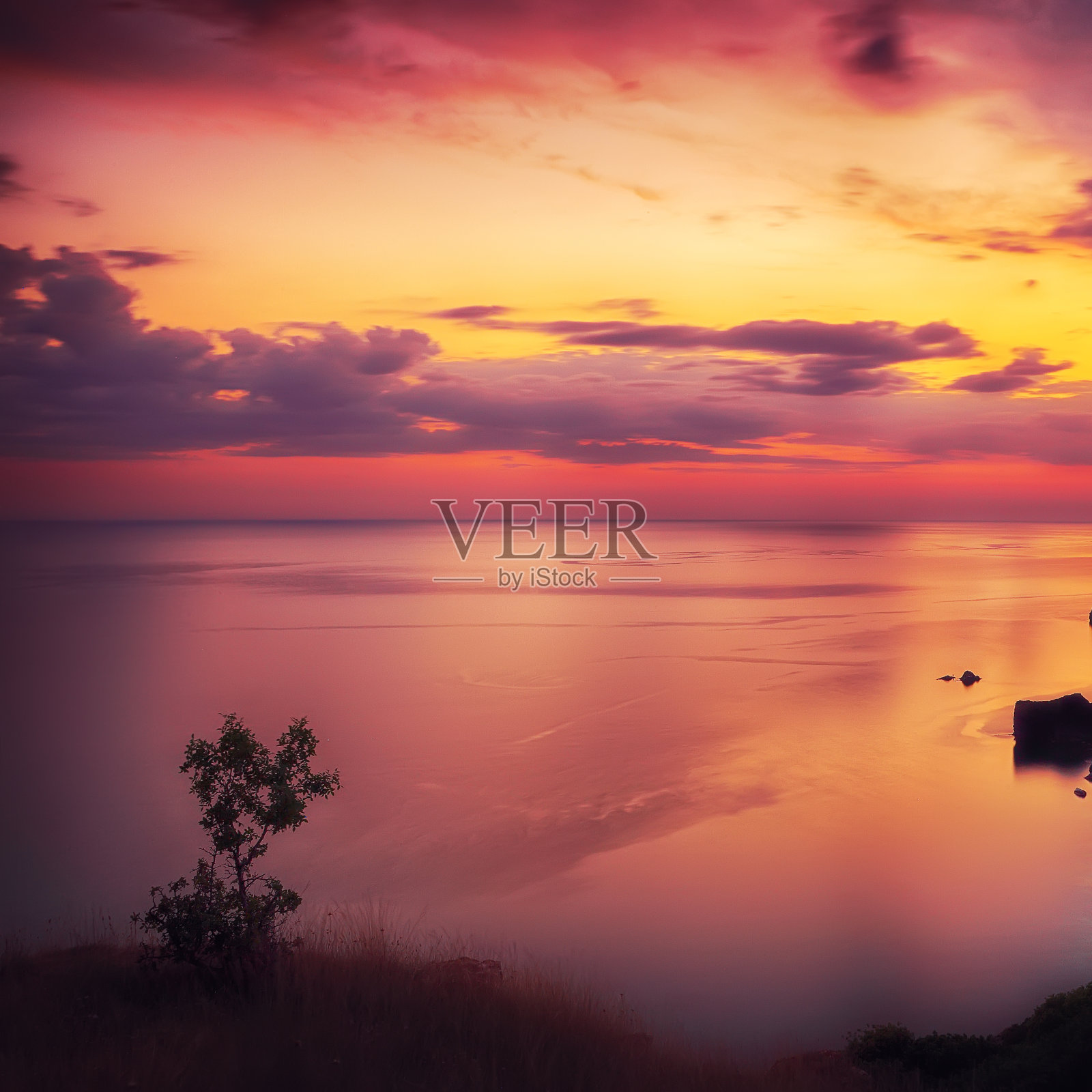 戏剧性的日落在海角与岩石和草地在前景照片摄影图片