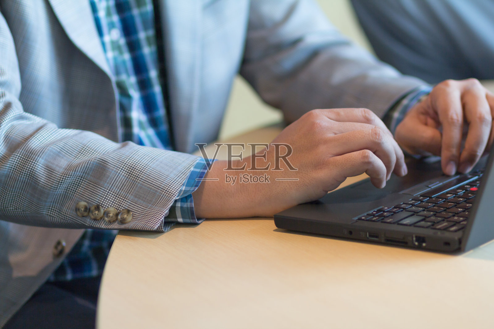 一名亚洲男子在笔记本电脑上打字。照片摄影图片