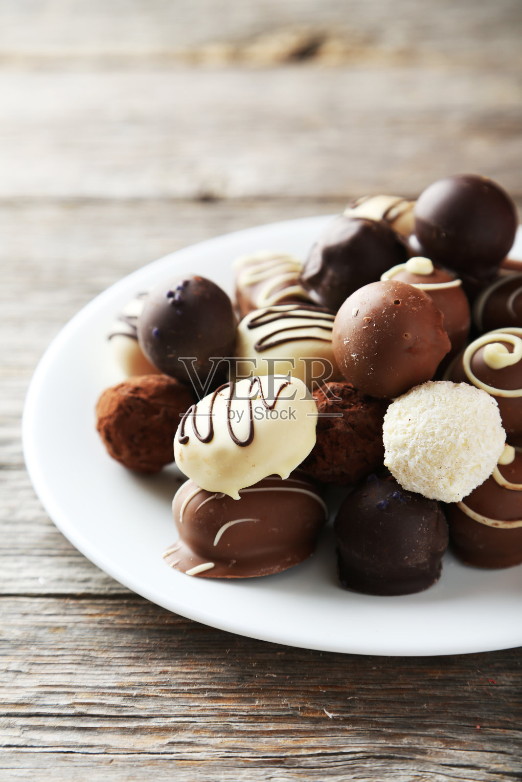 盘子里的巧克力放在灰色的木头背景上照片摄影图片