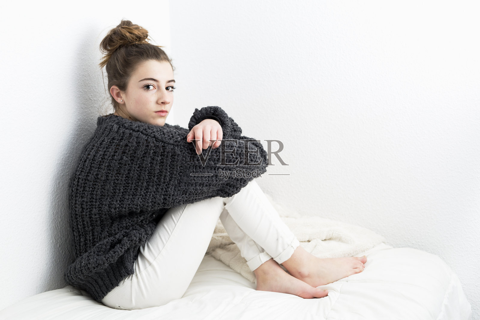 白种人背景下的年轻女子,面容严肃。照片摄影图片