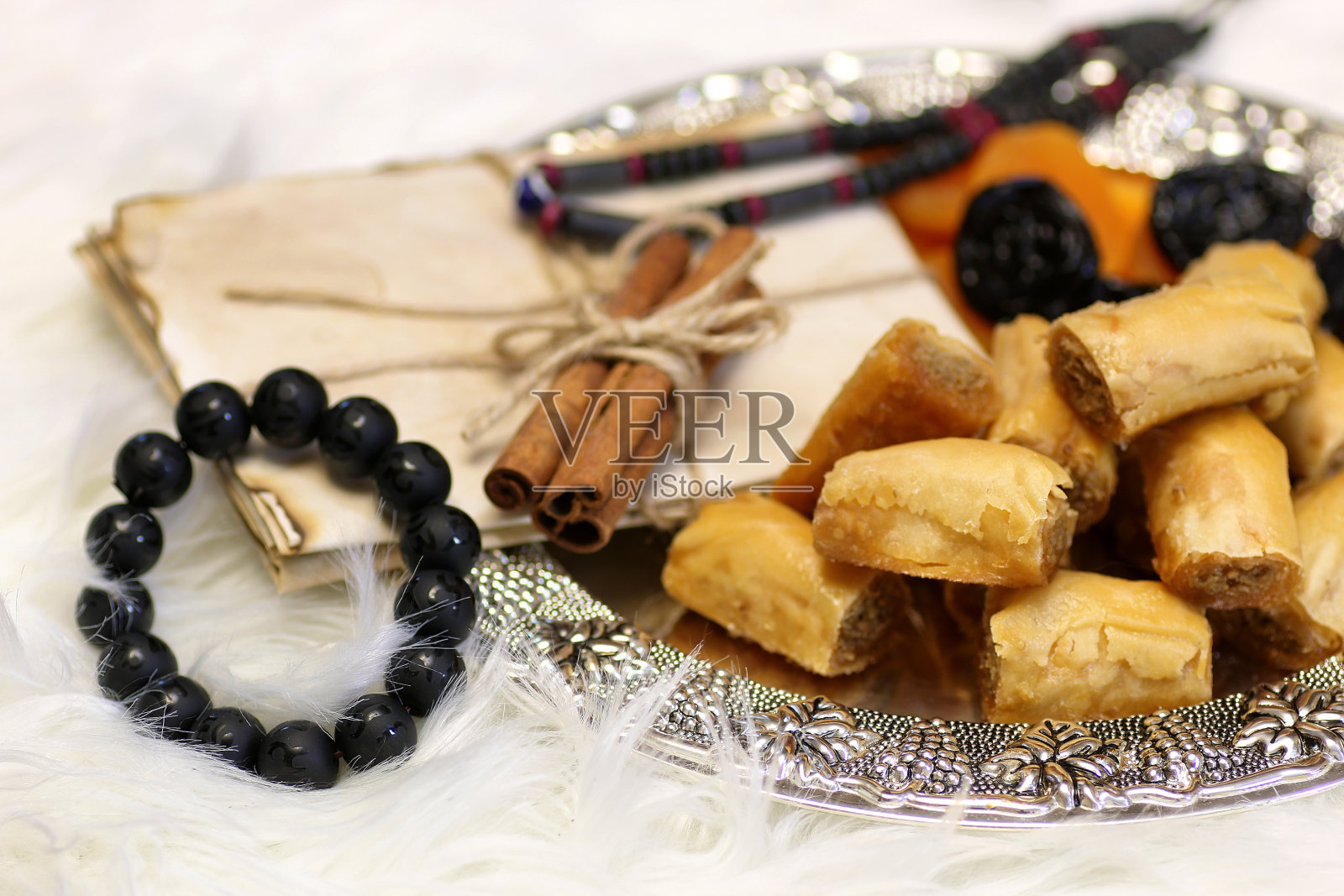 餐桌上放着东方甜点,银盘里放着果仁蜜和罗望子照片摄影图片