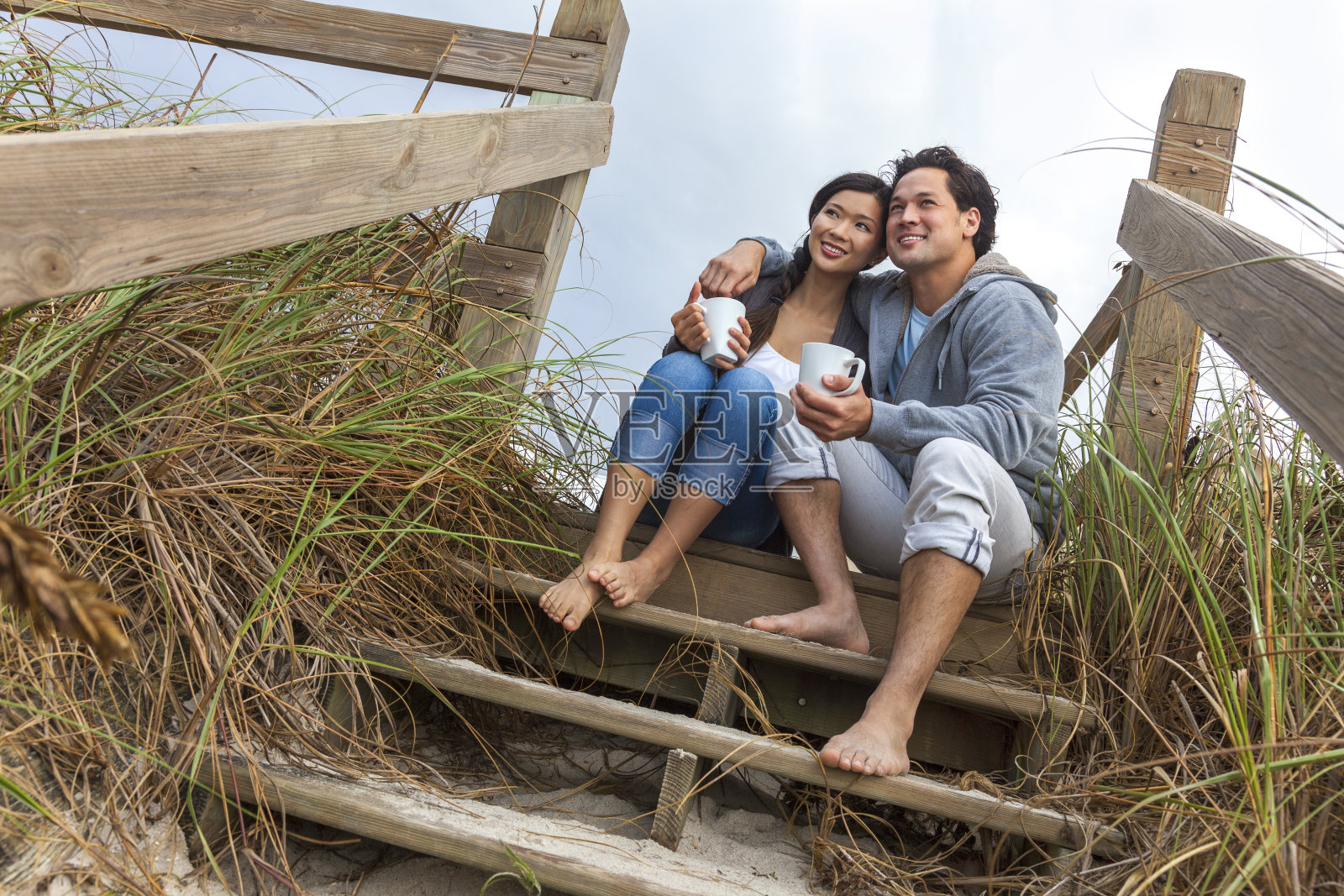 亚洲男女浪漫的夫妇在海滩台阶上照片摄影图片