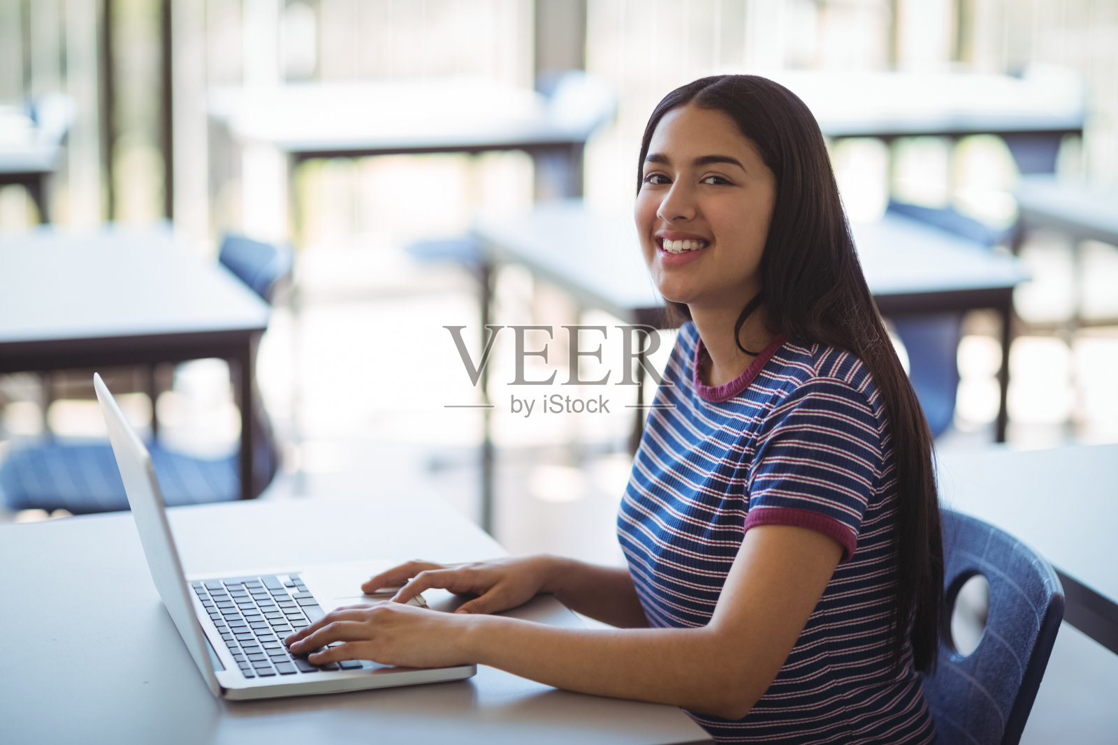女学生在教室里使用笔记本电脑的肖像照片摄影图片