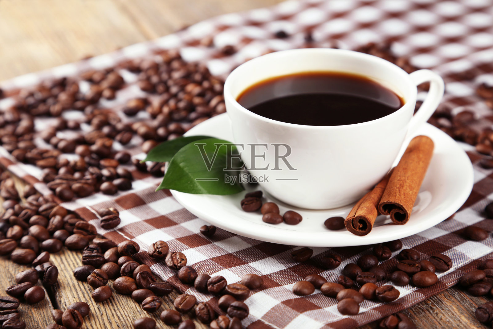 一杯咖啡,肉桂和树叶的木制背景照片摄影图片