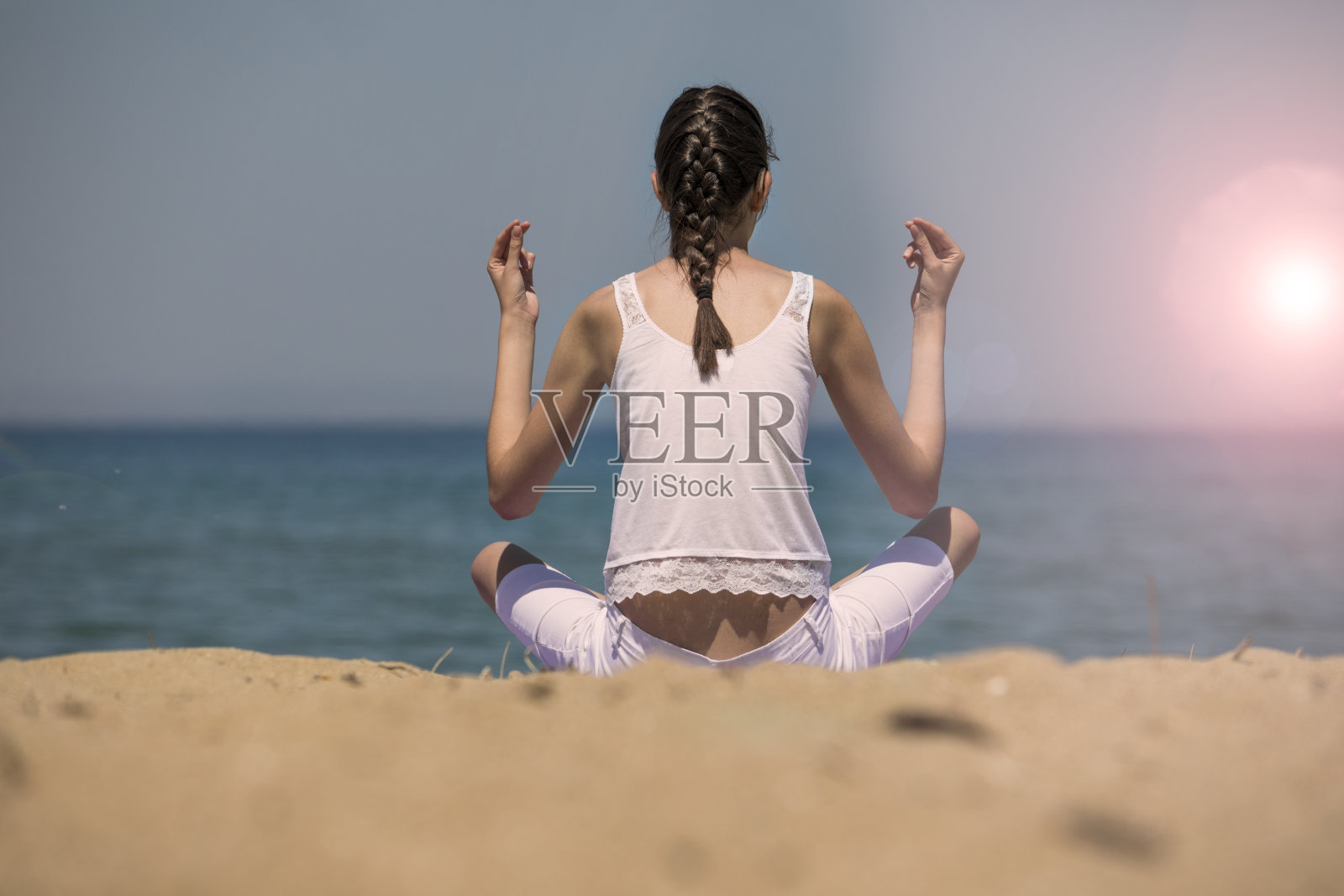 年轻的瑜伽女子在海滩上冥想照片摄影图片