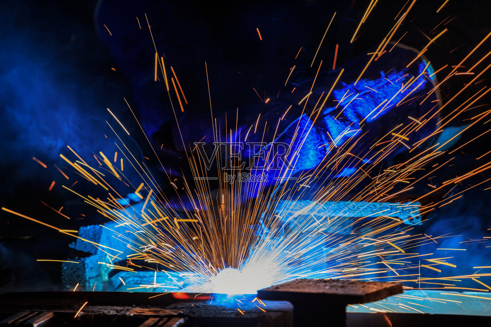 工人在工厂焊接钢材时的照明照片摄影图片