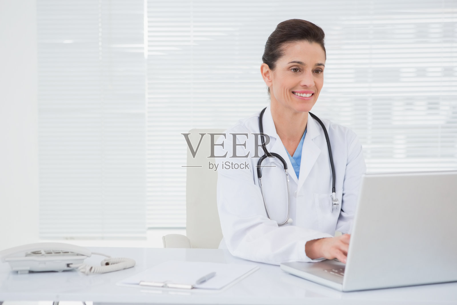 微笑医生使用笔记本电脑照片摄影图片