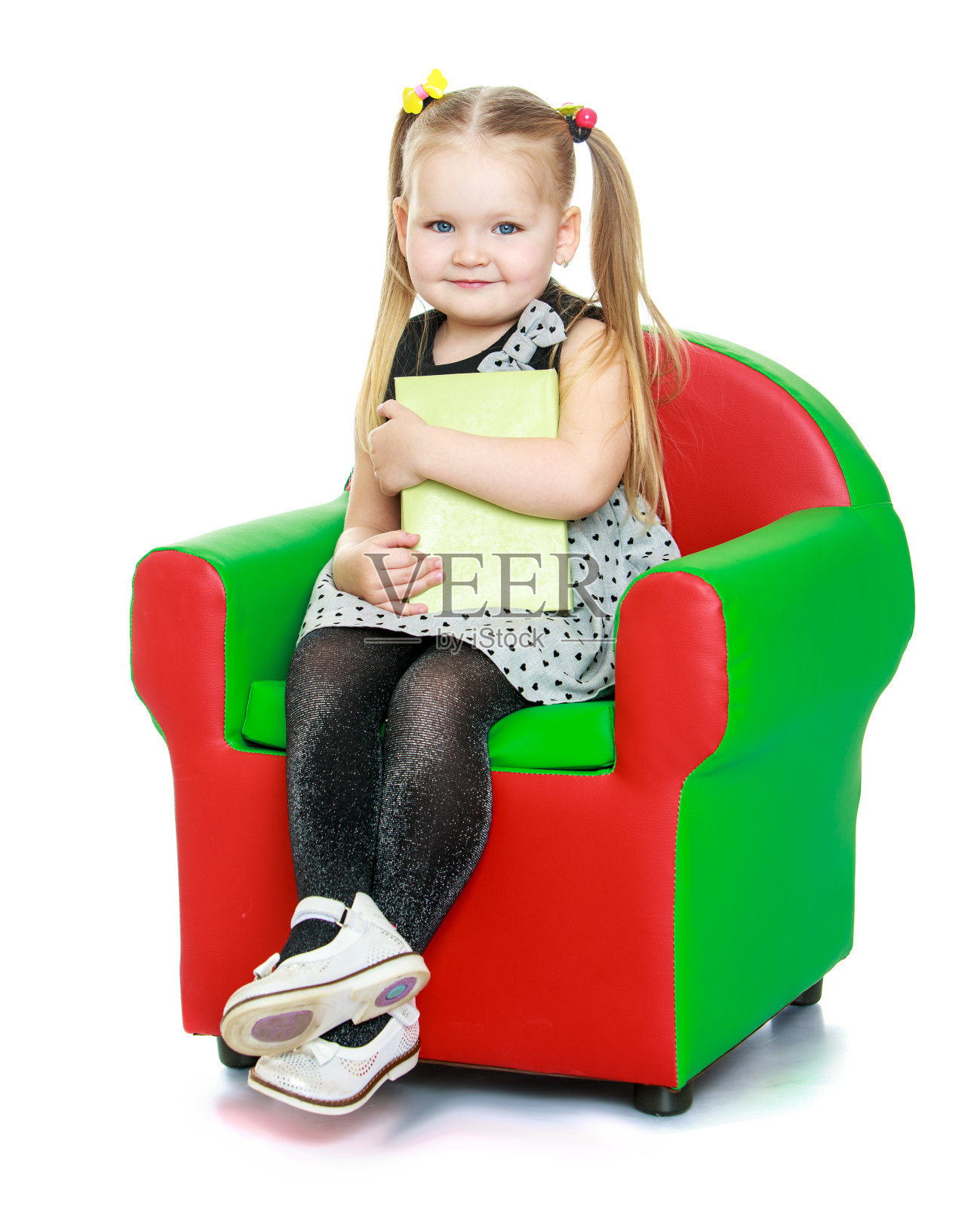 可爱的圆脸小女孩,头上扎着辫子照片摄影图片