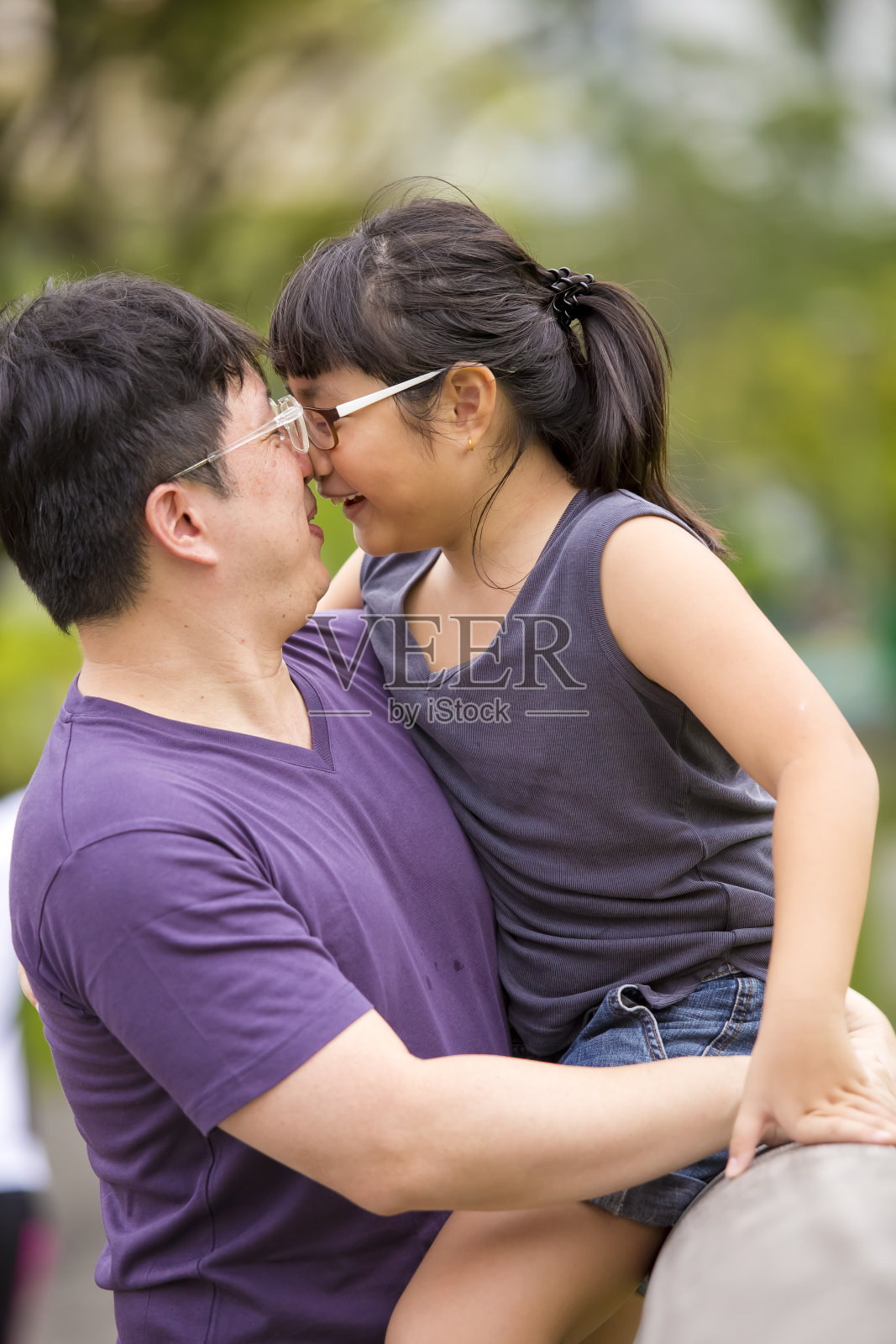 年轻的亚裔父亲和女儿在公园里照片摄影图片