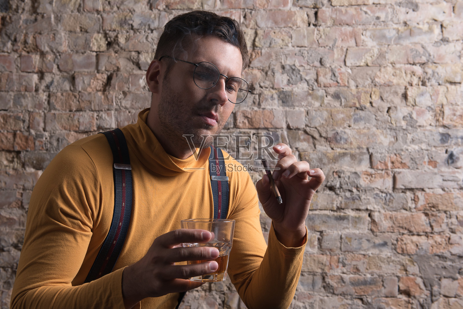 放松的男性喝威士忌和抽烟照片摄影图片