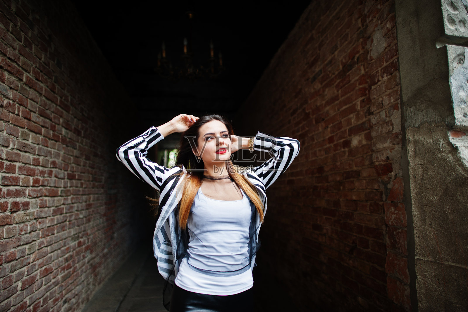 时尚女性看黑白条纹西装外套,皮裤。时尚女孩的概念。照片摄影图片